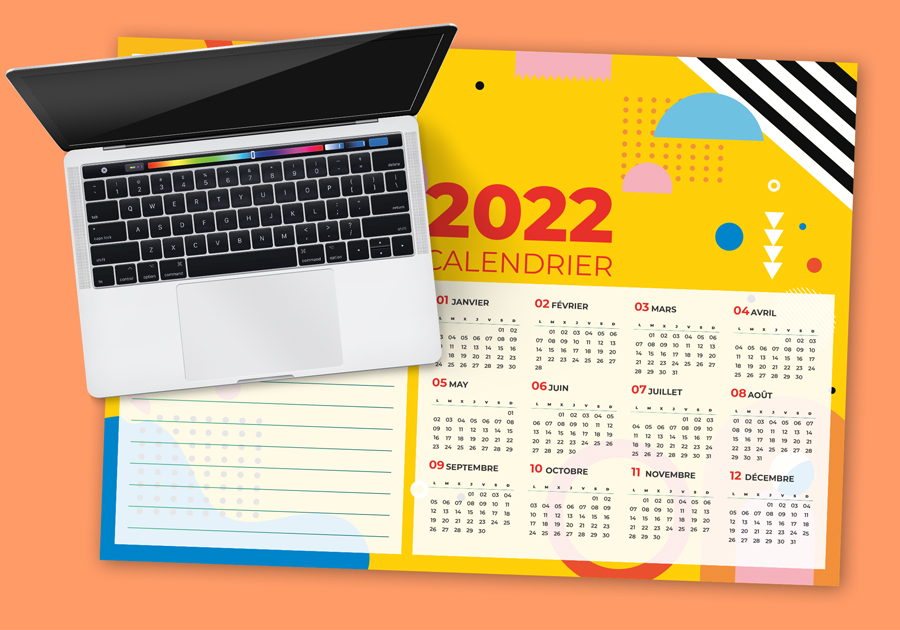 calendrier 2022 sous main sur fond orange avec un macbook posé dessus